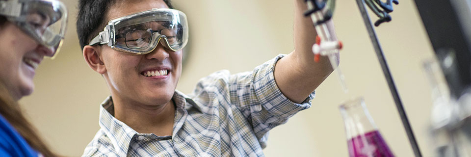 Biochemistry Student measuring liquid into a beaker