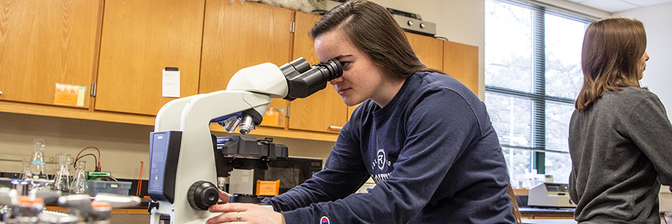 Biology Student using microscope