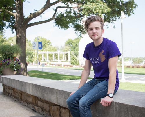 David Walter sits on a ledge that looks out over the Rockhurst campus