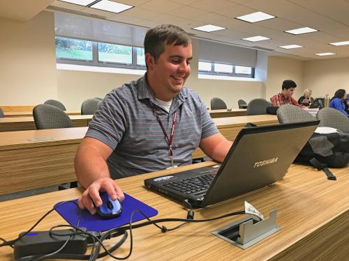 Kevin Bujarski travels from NW Arkansas for the Helzberg MS-BIA Kevin Bujarski sits at his computer in Conway Hall