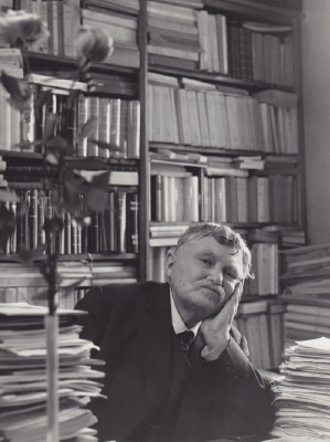 Gabriel Marcel sitting at his desk surrounded by papers