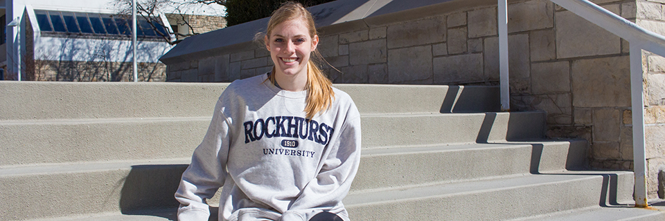 Karli Reichert sits on the steps by the bell tower