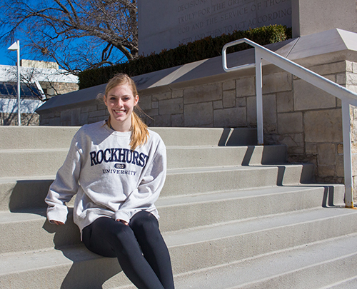Karli Reichert sits on the steps by the bell tower