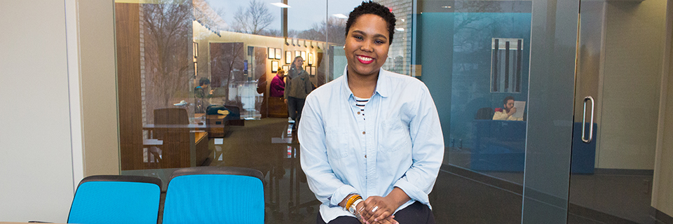 Kori Hines sits on a table in a meeting room in Arrupe. 