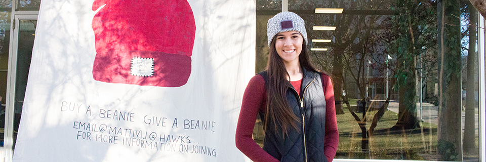 Julia Mattivi stands in front of a Love Your Melon banner.