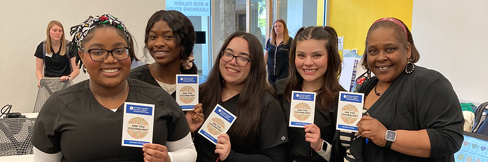 Four Medical Assisting students pose with their director, Donna Gardner, after conducting colorblind testing