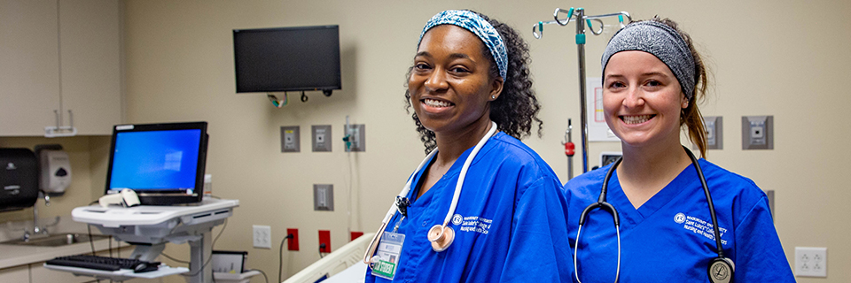 Nursing students with stethoscopes pose for the camera