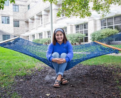 Paola Rodriguez sits in a hammock on campus