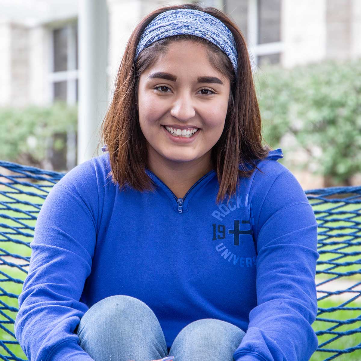 Paola Rodriguez sits on a hammock on campus.