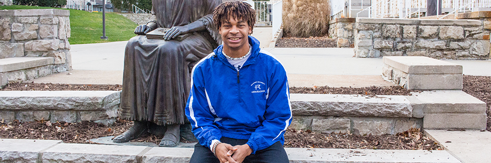 Shawn Taylor sits in front of the St. Ignatius statue