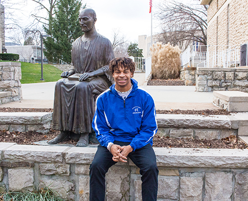 Shawn Taylor sits in front of the St. Ignatius statue