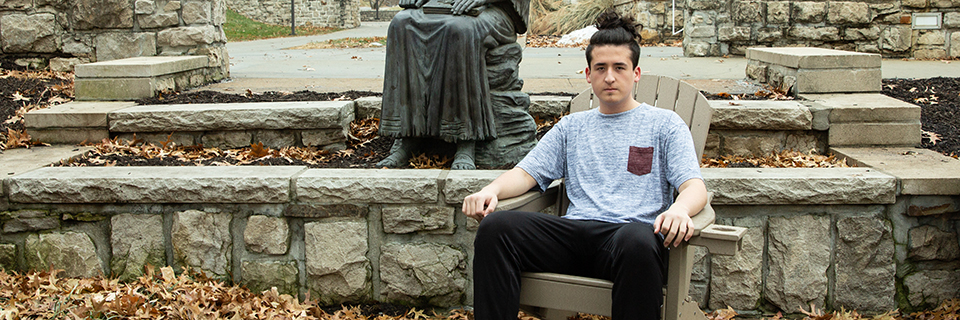 Stephen Wingo sits near the St. Ignatius statue