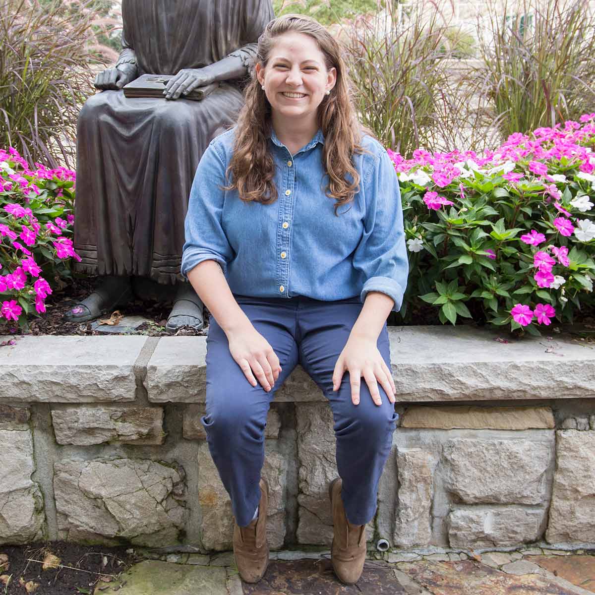 Claire Webster sits near the St. Ignatius statue