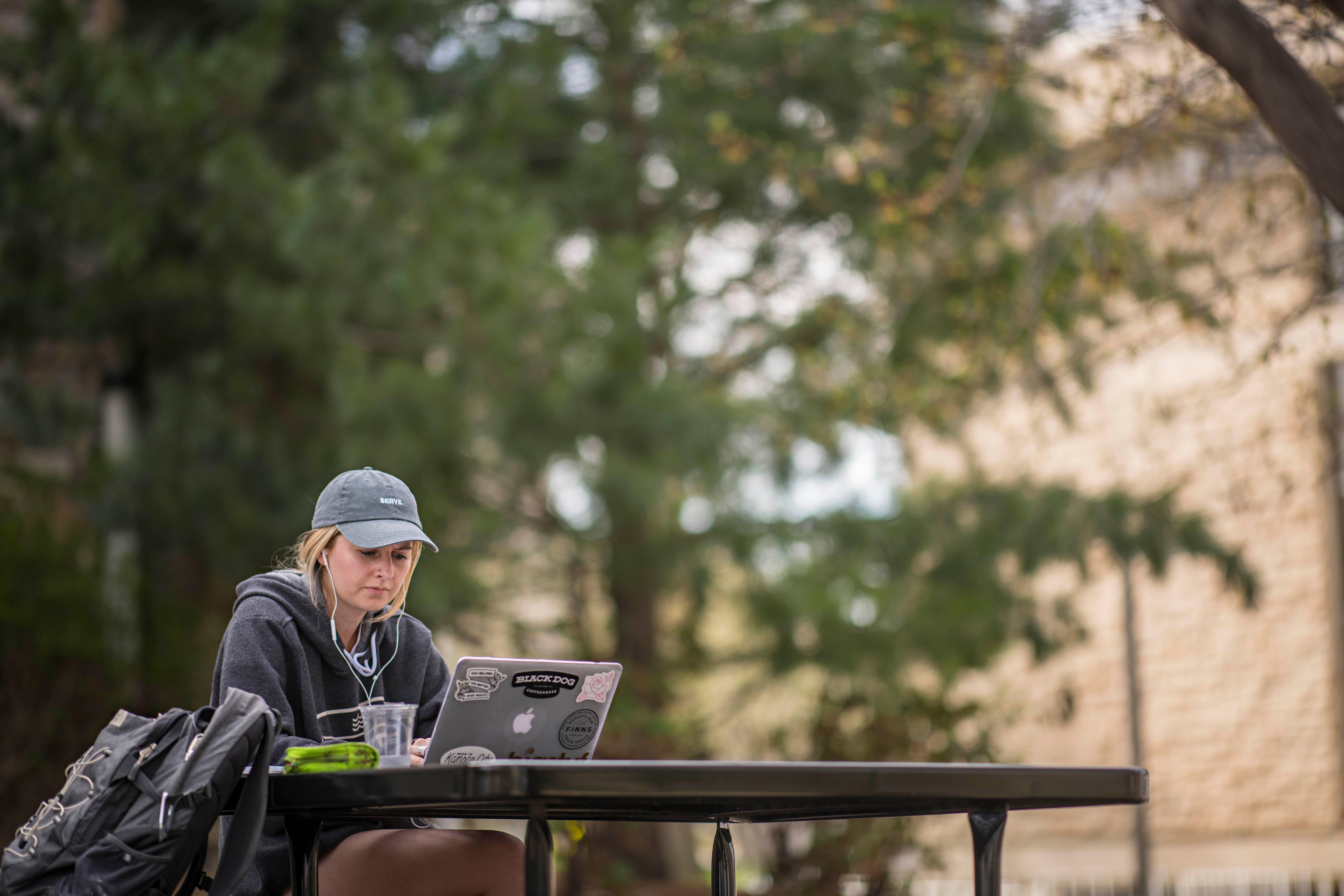 Student studying on laptop Student at table studying on laptop