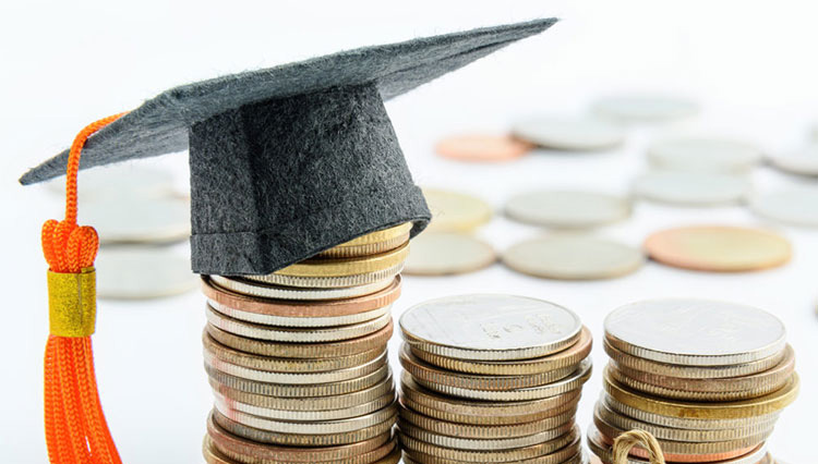 coins stacked with a graduation cap