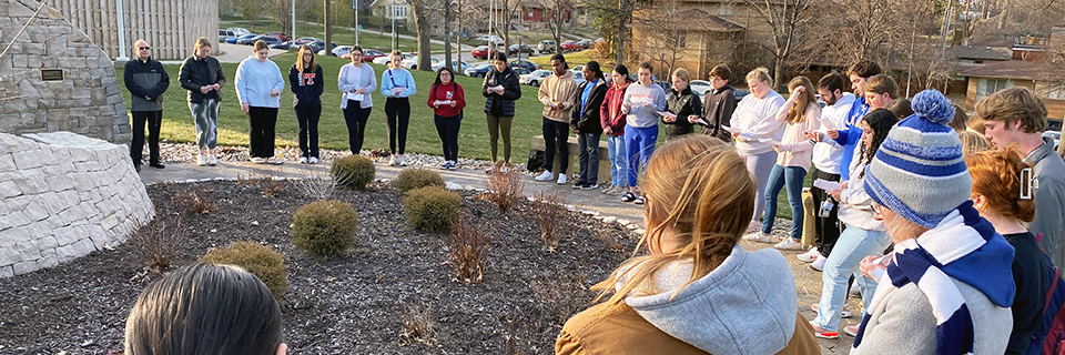 Campus Ministry Rosary Group gathers around the Mary statue