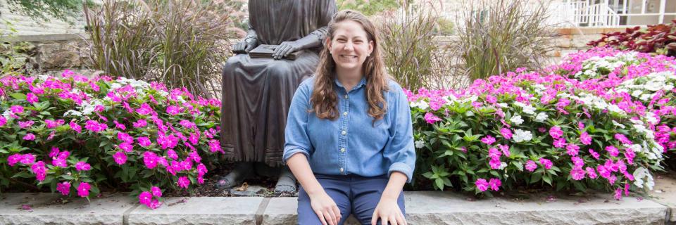 Claire Webster sits near the St. Ignatius statue