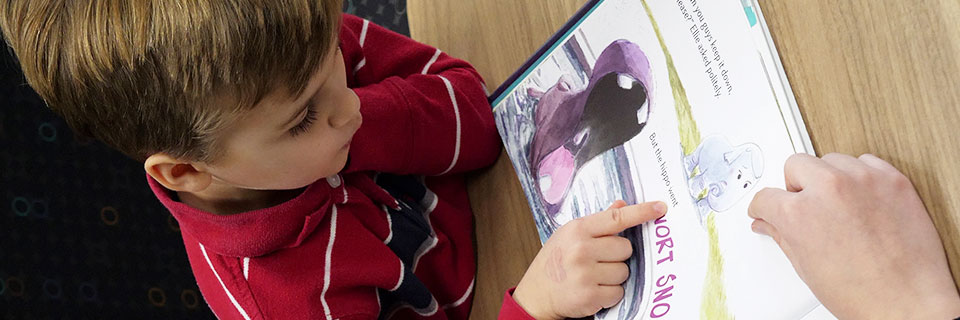 Student helping child read