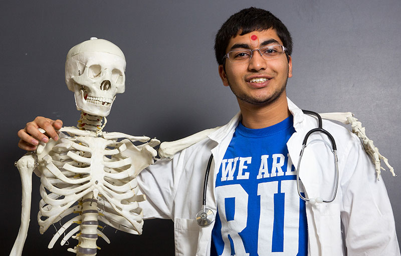 Recent Medical School Acceptances Pre-Med student posing with skeleton