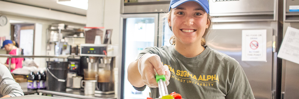 Laura Pezold serves fruit at NourishKC.