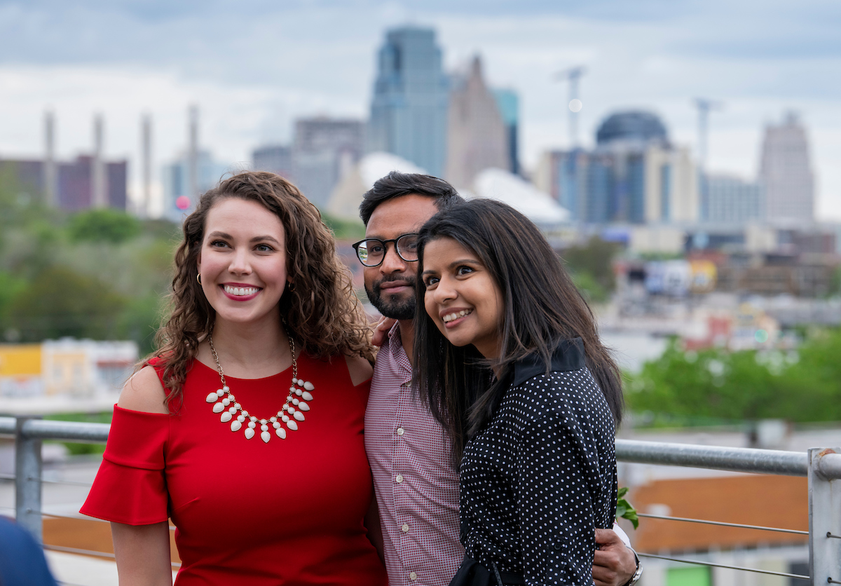 students standing in front of kansas city skyline