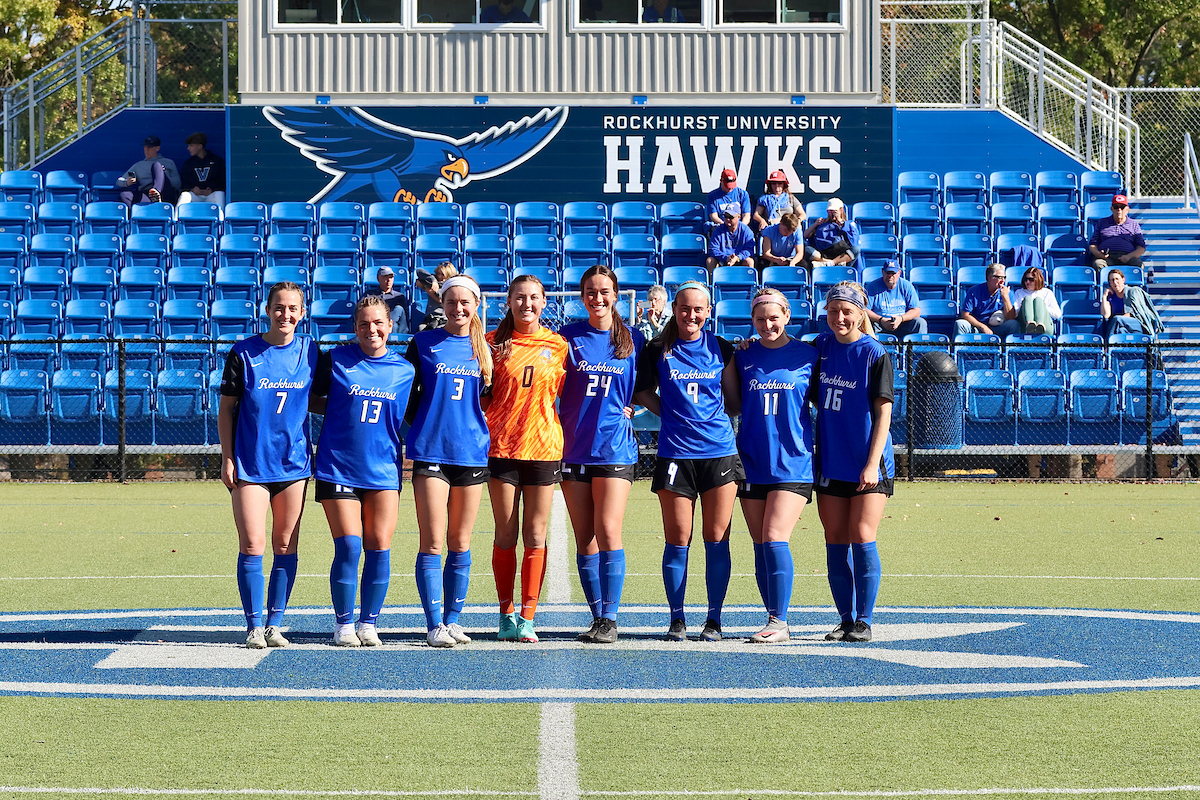 Women's Soccer 2024 senior pose in front of the Bourke Field bleachers