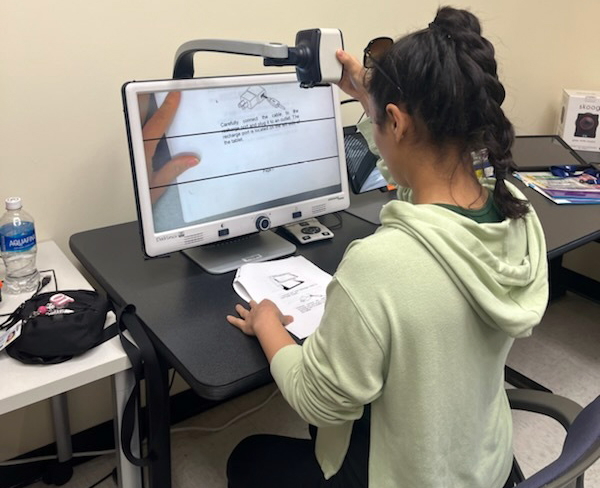 A worker studies an assistive technology device