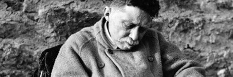 Gabriel Marcel, black and white photo in which he's looking at something in his hand