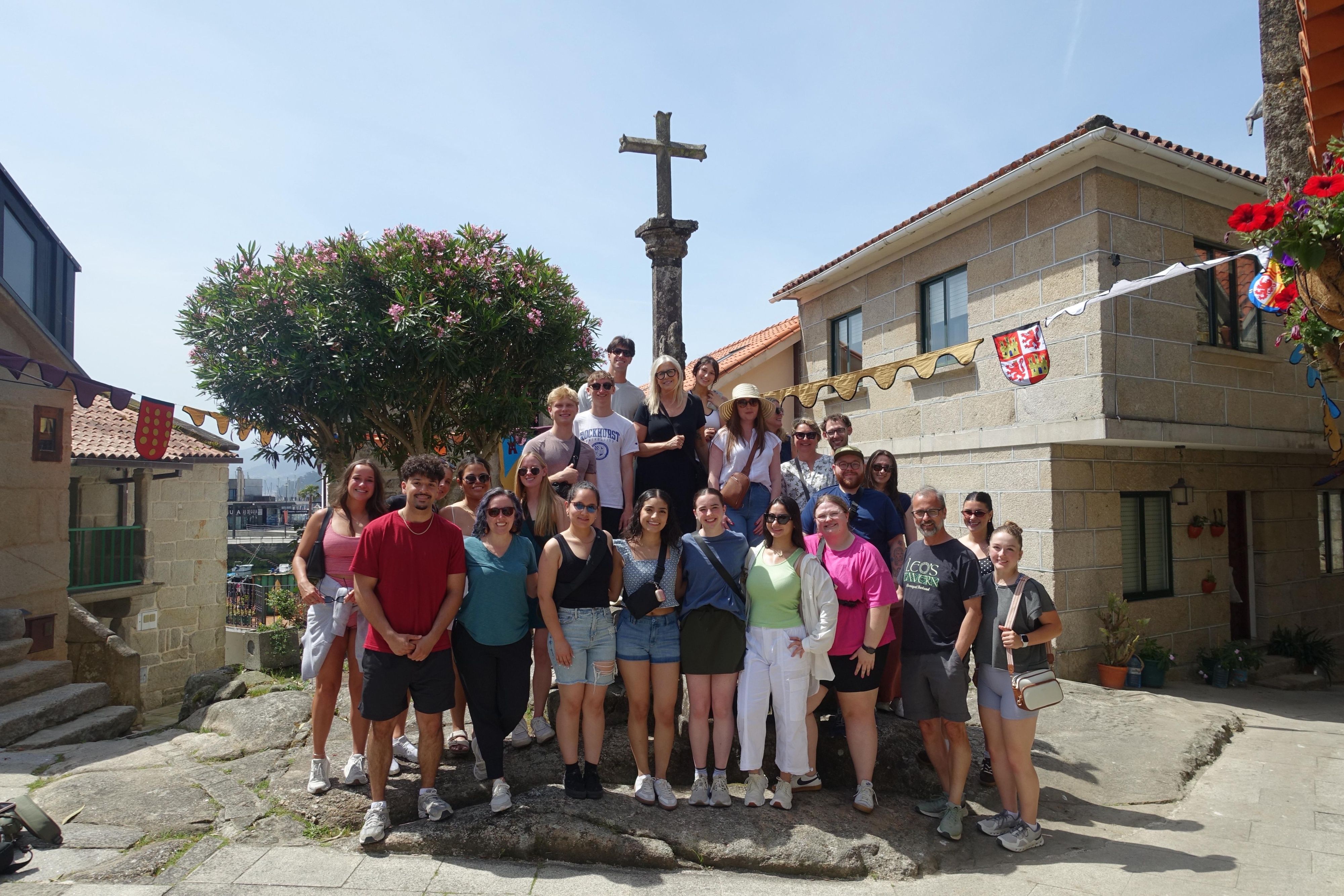 A group of study abroad participants stand in front of a cross in Pontevedra, Spain