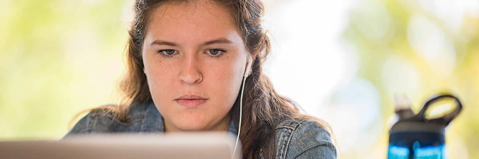 Female Rockhurst student watching a virtual event on her laptop