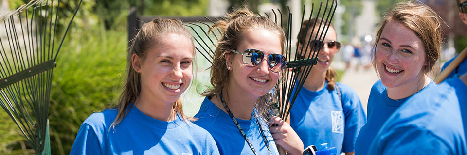 Students with rakes on campus