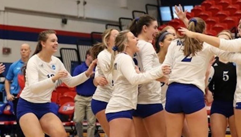 Volleyball team celebrating on the court