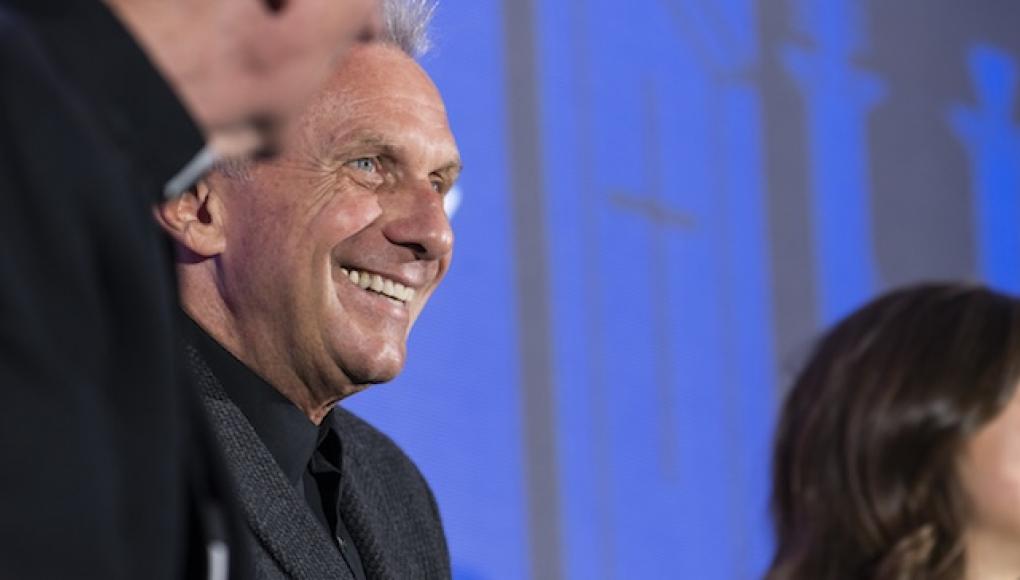 Joe Montana on stage with Rockhurst President and a student