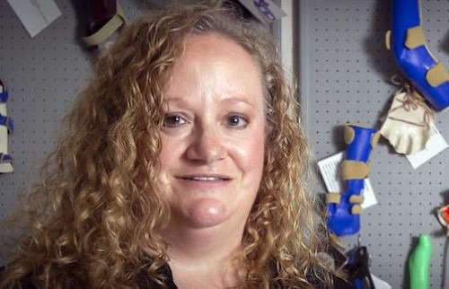 Amber Jenkins pictured in front of wall with occupational therapy devices