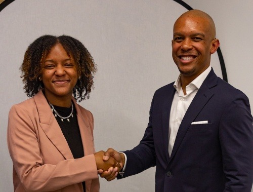 A female student and male professional shake hands at a networking event
