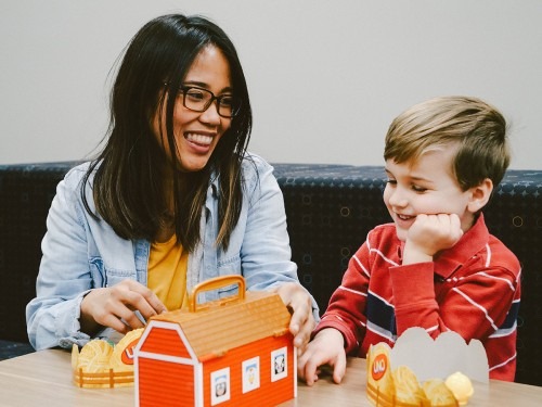 SLP student with boy, playing with toys while working on sounds