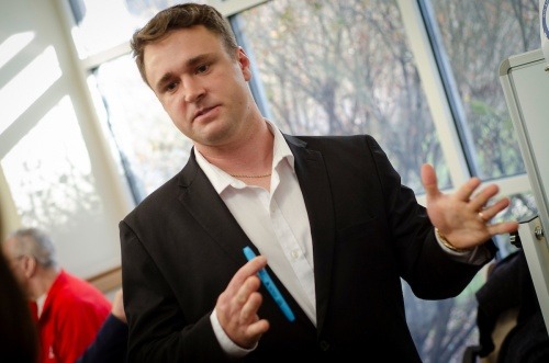 A male OT student holds a pen as he presents his capstone project