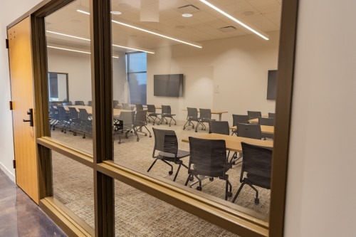 A conference room viewed through hallway glass