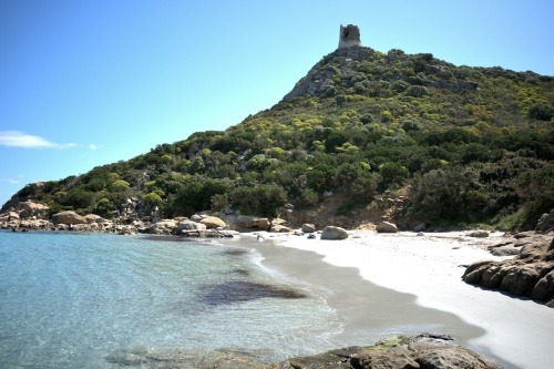 Ruins of an old tower sit on a tree-covered hill in Sardinia, Italy