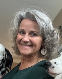 Stacey Corrado headshot with partial views of her dogs