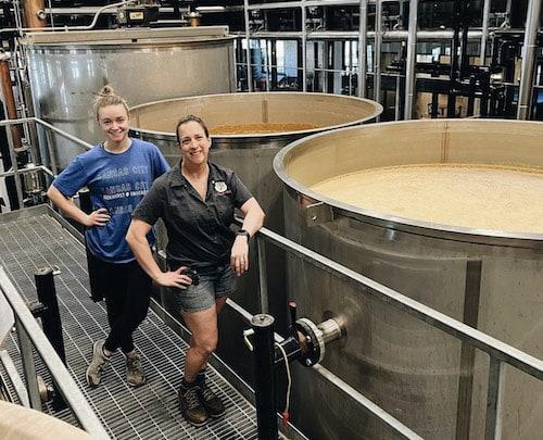 Emma Miller and a coworker at a distillery