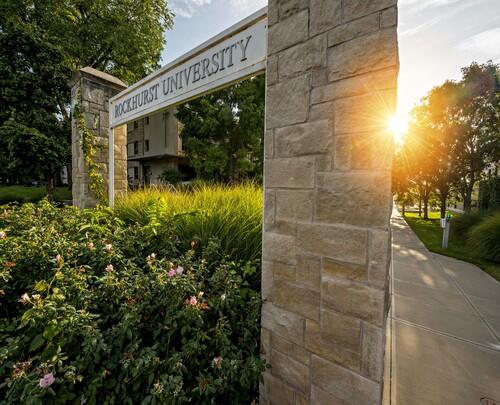 Sunset Picture of the Entrance of Rockhurst University on the Troost Side, Stone Wall with Plants Ar