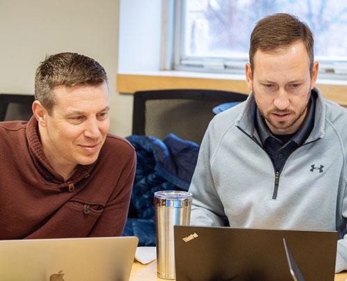 Two graduate business students focused on laptop 