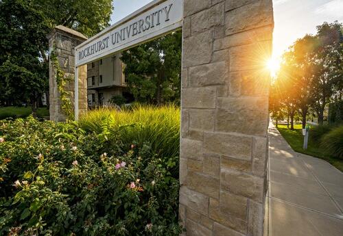 Sunset Picture of the Entrance of Rockhurst University on Troost Side, Stone Wall with Plants Around